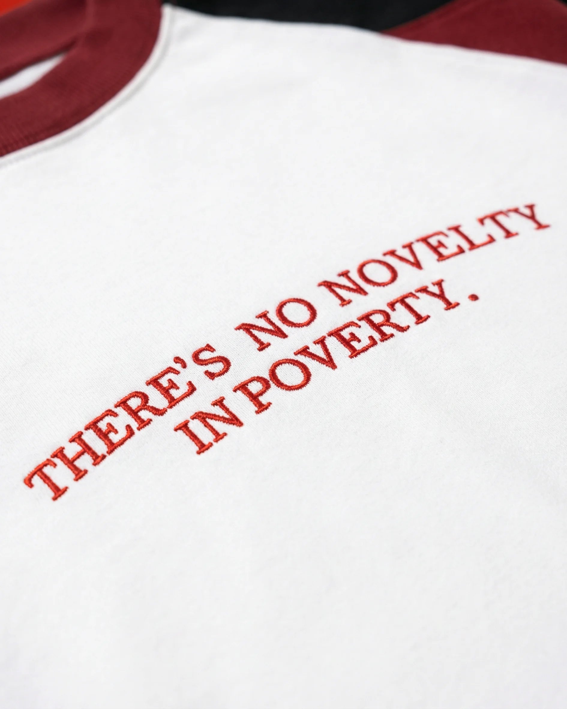 NO NOVELTY IN POVERTY TEE
